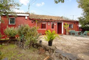 贝加德圣马特奥Casa Rural La Asomada的红色的房子前面设有庭院