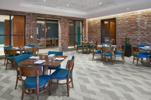 华盛顿华盛顿市中心/会议中心万怡酒店的餐厅设有木桌和蓝色椅子