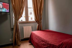 罗马德埃斯特酒店的一间卧室设有红色的床和窗户。