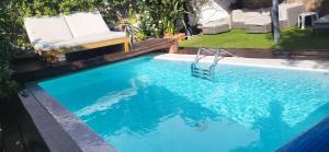 法塔加Casa Agustín Pool 27 ºC的一个带椅子和蓝色海水的游泳池