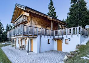 沃尔夫斯堡1A Chalet Koralpenzauber - Wandern, Sauna, Grillen mit Traumblick的小木屋的一侧设有阳台