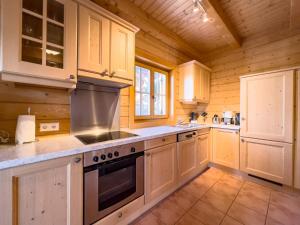 沃尔夫斯堡1A Chalet Koralpenzauber - Wandern, Sauna, Grillen mit Traumblick的厨房配有白色橱柜和炉灶烤箱。