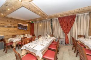 塞斯特雷HOTIDAY Chalet Sestriere Vialattea的用餐室设有桌椅和木墙