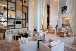 迪拜Hotel Boulevard, Autograph Collection的带沙发和椅子的大堂以及酒吧