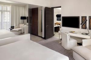 迪拜Hotel Boulevard, Autograph Collection的白色的酒店客房,配有床和电视