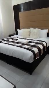 比勒陀利亚DBrite的一张大床,配有黑白床单和枕头