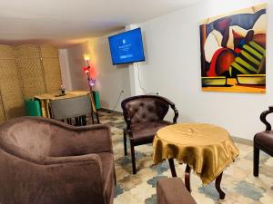 利伯维尔Namaste hotel & restaurant的客厅配有椅子、桌子和绘画