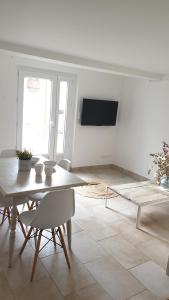 圣马迪拉莫Appartement LE BOIS FLOTTE的白色的客厅配有桌子和电视。