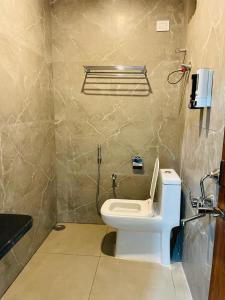 商沙巴Hotel Blue Petals的一间带卫生间的浴室和墙上的一部电话