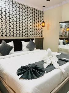 商沙巴Hotel Blue Petals的一间卧室配有两张床和白色毛巾。