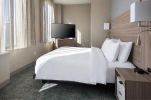 布鲁克林TownePlace Suites by Marriott New York Brooklyn的一间酒店客房,配有白色的床和一台平面电视