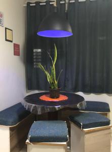 伊塔尼亚恩Apartamento Belas Artes Itanhaém的一张桌子,上面有盆栽植物和蓝光