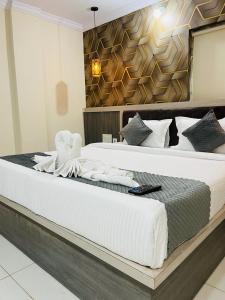 商沙巴Hotel Blue Petals的一间卧室配有一张带白色床单的大床