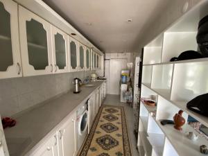 伊兹密尔Kuzey’s home的厨房配有白色橱柜和洗衣机。