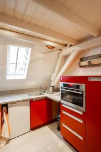 OudewaterDe Kapelle in Oudewater的厨房配有红色橱柜和红色烤箱
