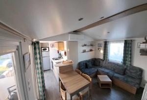莱马特davorel mobil home的客厅配有沙发和大篷车内的桌子