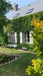 PréverangesLa Tour du Boueix的院子中长着长凳的常春藤遮盖的房子