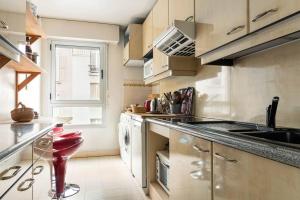 巴黎Charmant 3P. Calme, spacieux et lumineux. 90 m2的厨房配有柜台和红色凳子