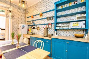 里斯本安比恩特旅舍的蓝色的厨房,配有桌子和蓝色橱柜