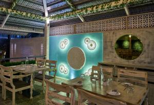 戈尔哈布尔Ramee Panchshil的一间带桌椅和板墙的餐厅