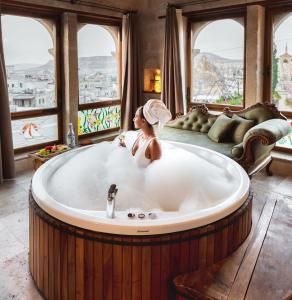 格雷梅苏丹洞穴套房酒店的窗户间里浴缸里的女人