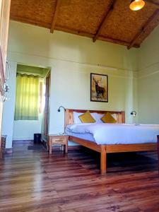 穆克缇斯瓦Chirping Orchard, Mukteshwar的一间卧室设有一张大床,铺有木地板