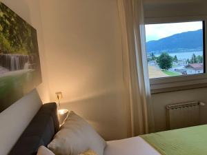 赛特朵夫Ferienhaus Julia - Ossiacher See的一间卧室设有一张床和一个美景窗户。