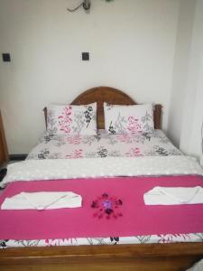 哈普特莱Dinu Homestay的一张带粉色和白色床单及枕头的床