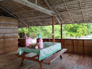 WaisaiRaja Ampat Diva homestay的一张桌子,放在带长凳的屏蔽门廊上