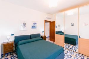拉维罗Casa Vacanze La Trinità的一间卧室配有蓝色的床和镜子