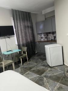 伊斯坦布尔Zerya suites的一间带桌子和冰箱的小厨房