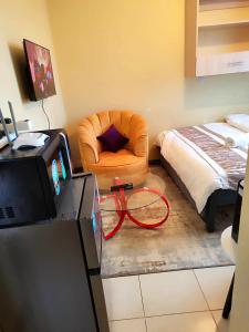 KikuyuThe Little Haven - Ample Parking, Views & Netflix的客厅配有椅子和床