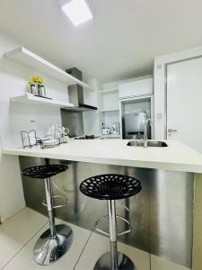 哥打京那巴鲁Hstay Sutera Avenue 2Bedroom by Aida的厨房在柜台上设有两个吧台凳