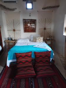 锡瓦مراقي سيوة Maraqi Siwa的一间卧室配有一张带蓝色床单和两个枕头的床