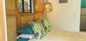 诺萨拉Casita Vinita的一间卧室配有一张带枕头的床和吊灯。