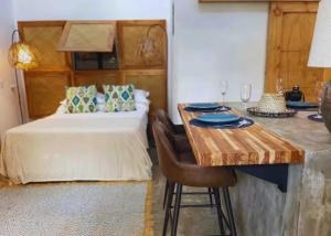 诺萨拉Casita Vinita的一间卧室配有一张床和一张带酒杯的桌子