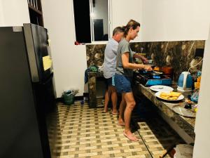 米瑞莎Royal Palace Mirissa的两个人站在厨房准备食物