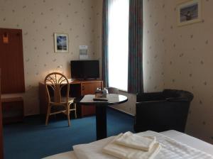奥斯特巴特宁哈根尼恩哈格斯塔德酒店的酒店客房设有床、桌子和电视。