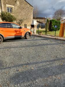 Saint-Sulpice-de-FaleyrensGîte Mimi的停在街道边的橙色汽车