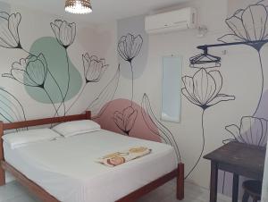 纳塔尔Jambudvipa Hostel的卧室配有一张墙上鲜花的床