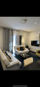 达喀尔Meublé Nord Foire Dakar的客厅配有2张白色沙发和1台电视