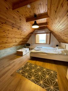 哈卡尼Alma Apartmanház的一间卧室设有一张床和木制天花板