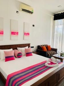 坦加拉Kalametiya Bird Villa的一间卧室配有一张带色彩缤纷枕头的大床