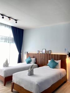 Ban Khlong HaengBlue Ba You Resort的两张位于酒店客房的床,配有蓝色窗帘