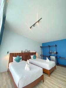 Ban Khlong HaengBlue Ba You Resort的蓝色墙壁客房的两张床