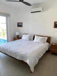 PochoteCasa Gravel的一间卧室配有一张带白色床单的床和风扇