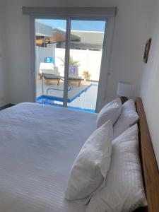 PochoteCasa Gravel的卧室设有一张白色床,享有游泳池的景色
