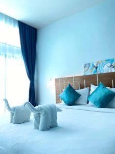 Ban Khlong HaengBlue Ba You Resort的一间卧室配有白色床和蓝色枕头