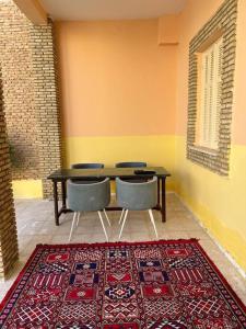 托泽尔Dar Medina Tozeur的一间带桌椅和地毯的用餐室