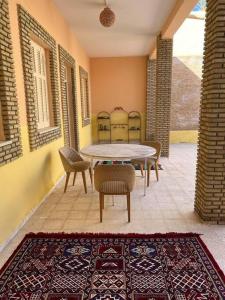 托泽尔Dar Medina Tozeur的庭院配有桌椅和地毯。